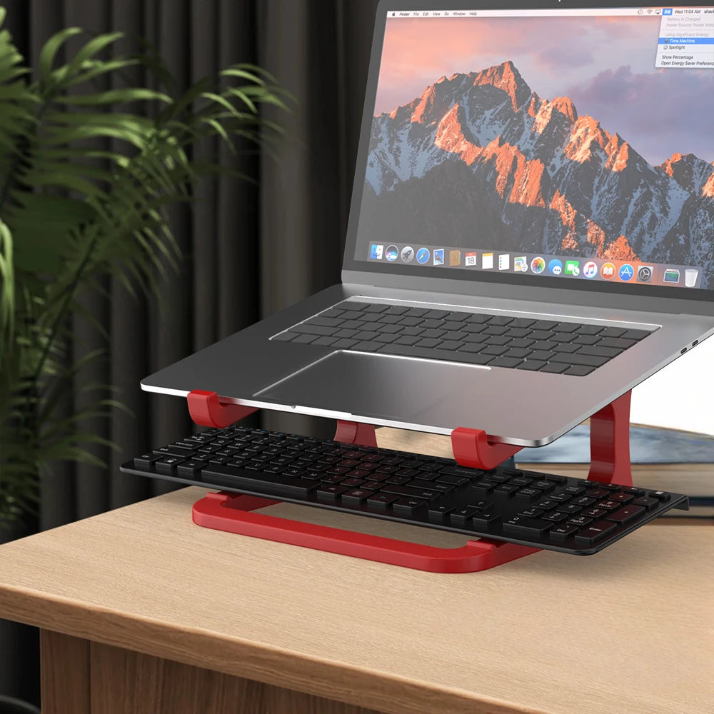Laptop on a red stand with a mountain-themed screen on a wooden desk.