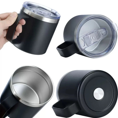 Black insulated mug with silver lid and handle, held by a hand.