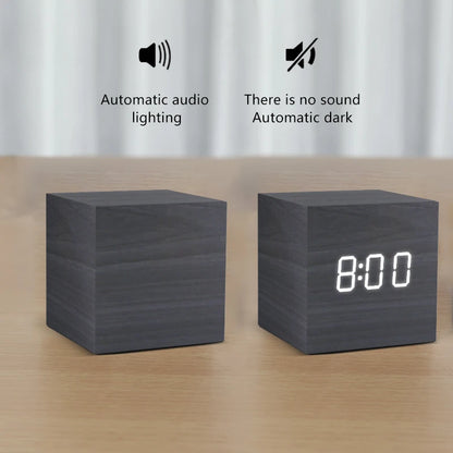 Two black cube-shaped devices on a wooden surface with text indicating features.