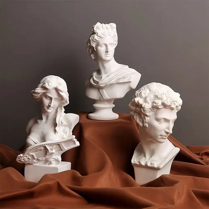 Three classical busts on a brown fabric background