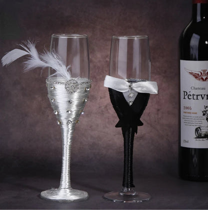 Decorative wine glasses shaped like a bride and groom with a bottle of Chateau Petril in the background.