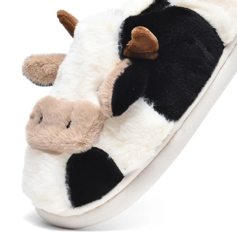 Plush cow slipper with black and white pattern on a white background