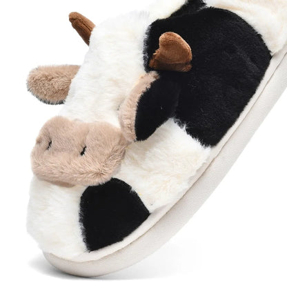 Plush cow slipper with black and white pattern on a white background