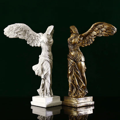 Two statues, one white and one gold, on a reflective surface with a dark background