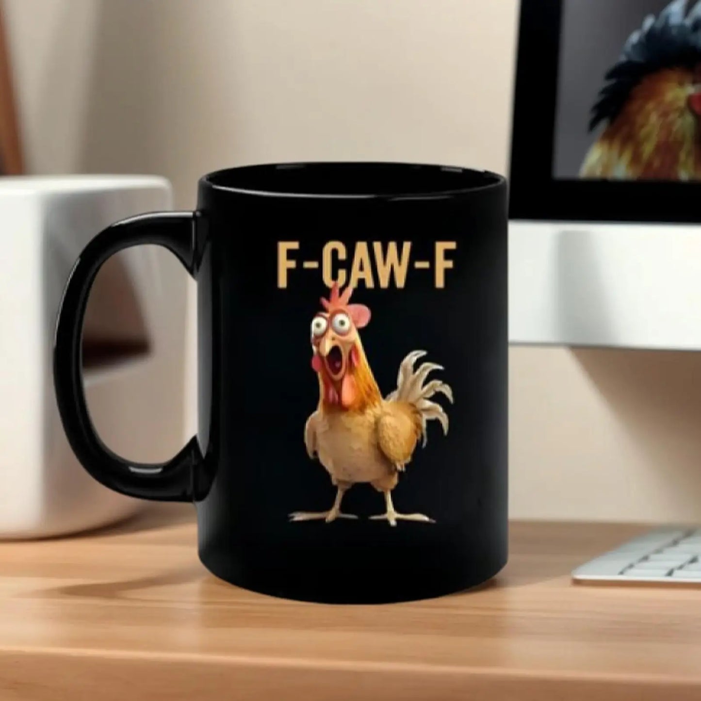 Black mug with a cartoon rooster and 'F-CAW-F' text on a desk.