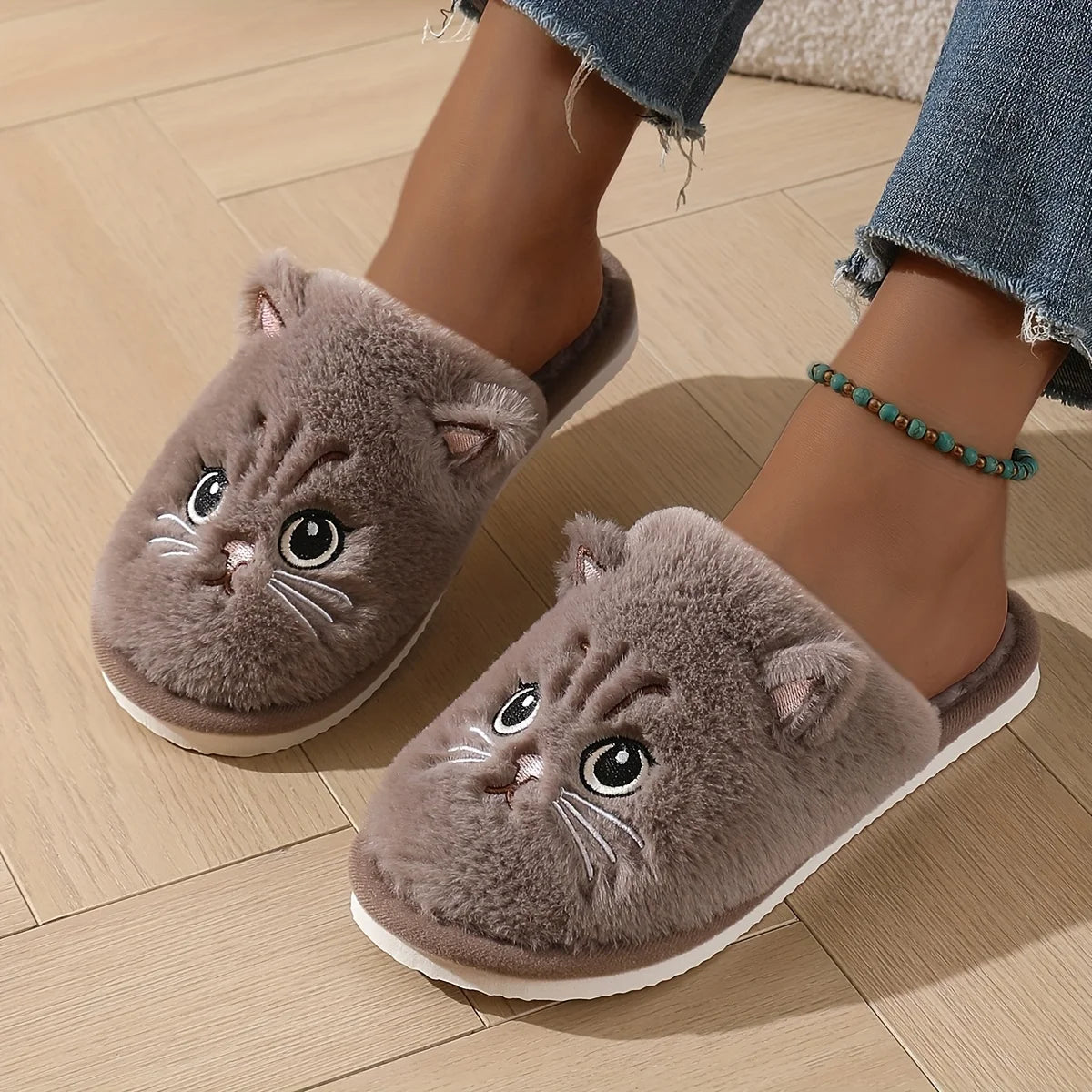 Cat-shaped slippers worn on a wooden floor