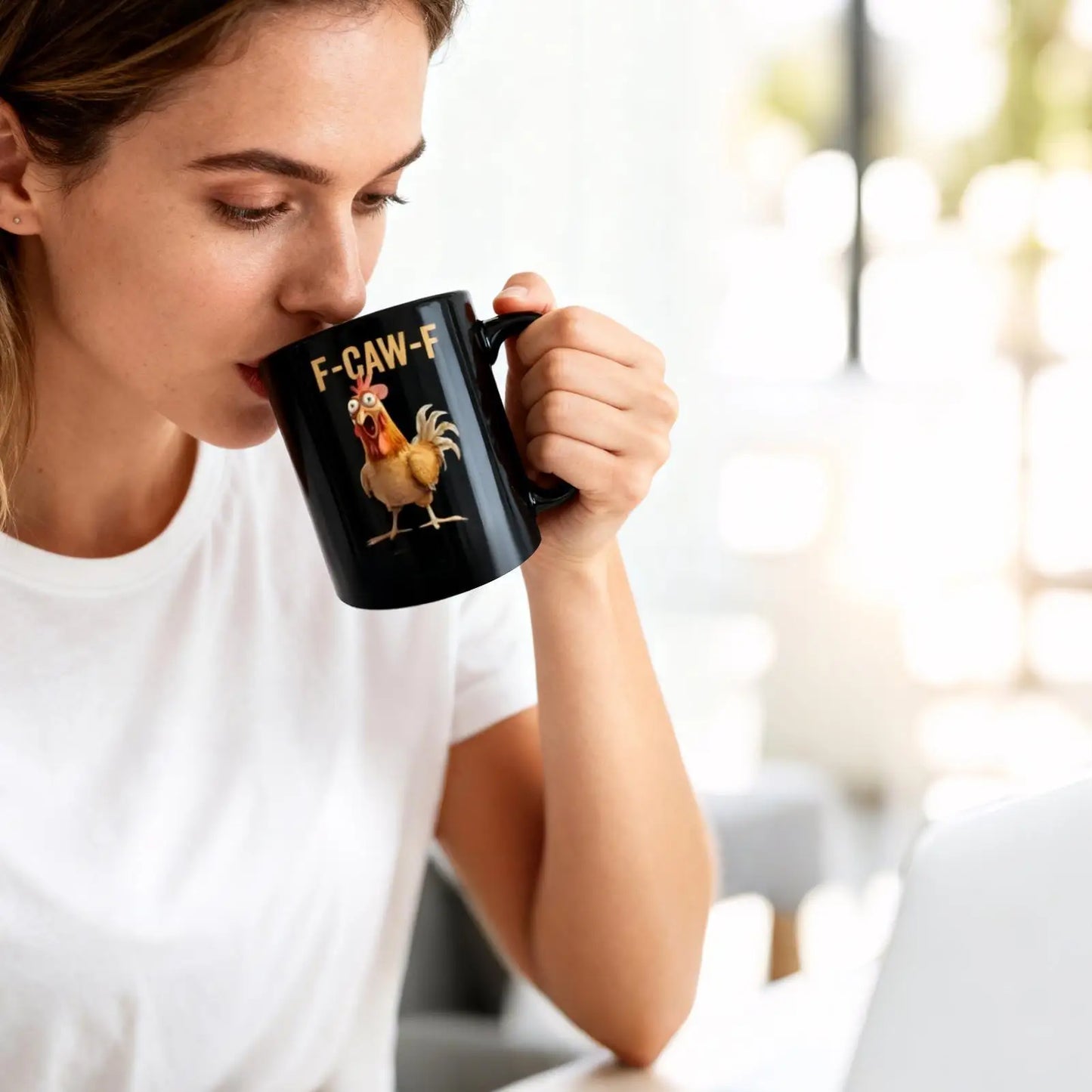 Woman drinking from a black mug with a rooster design and 'F-CAW-F' text.