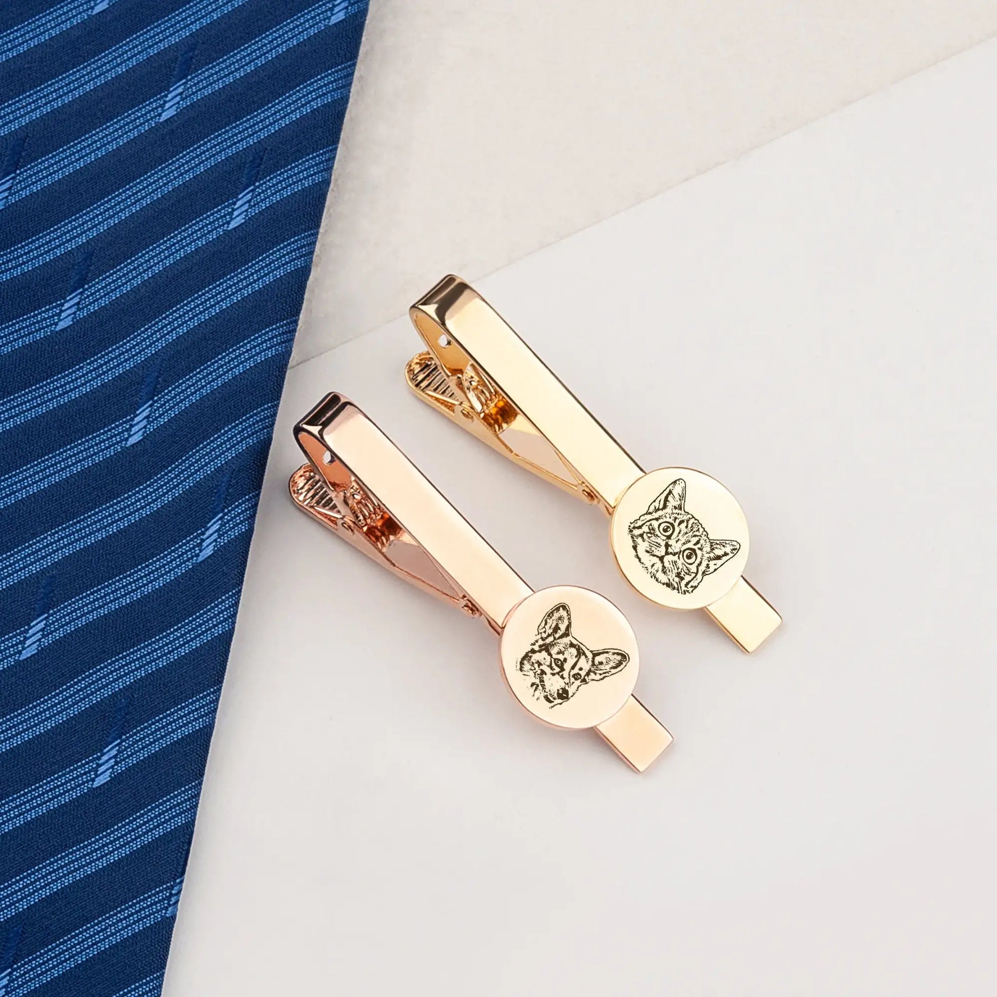 Two gold hair clips with dog design on a blue and white background