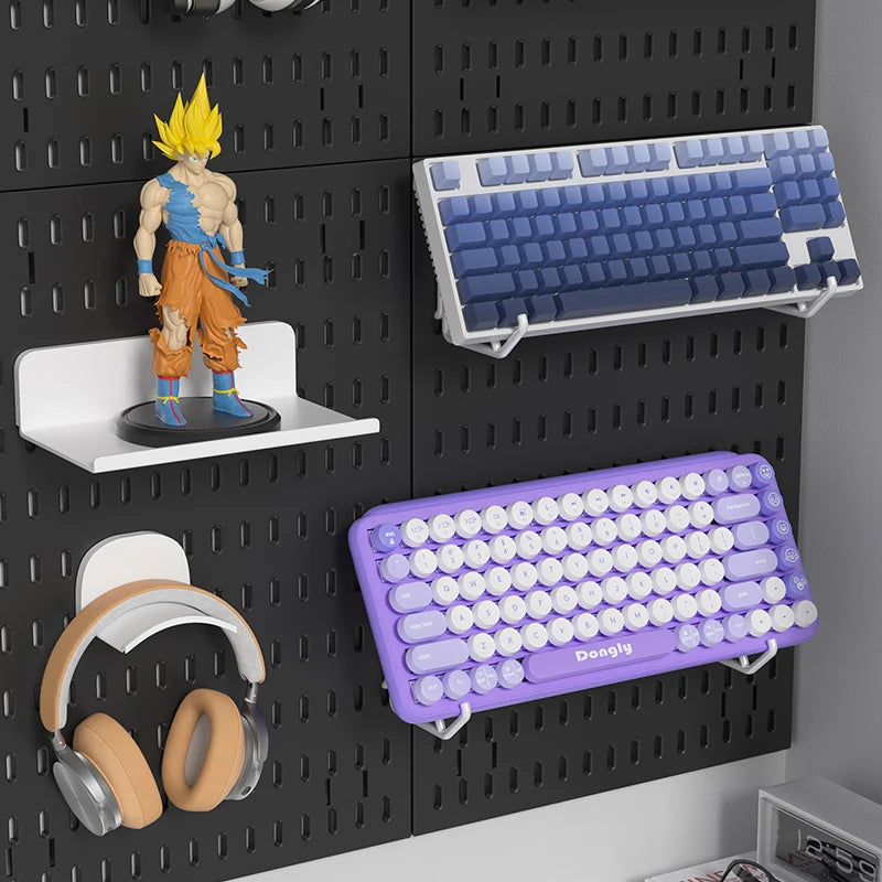Pegboard with keyboard, figurine, and headphones on a black pegboard wall.
