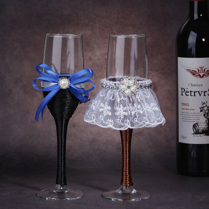 Two decorative wine glasses with a blue bow and lace skirt, next to a bottle of Chateau Petrus.