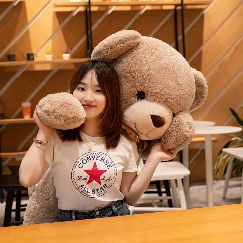 Woman holding a large teddy bear in a casual indoor setting