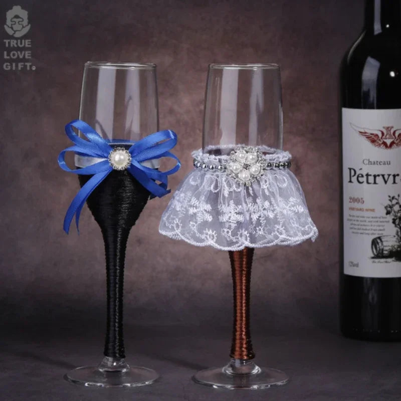 Decorative wine glasses with a blue bow and lace skirt next to a bottle of Chateau Petrv.