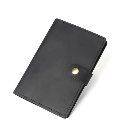 Black leather notebook with a gold button on a white background