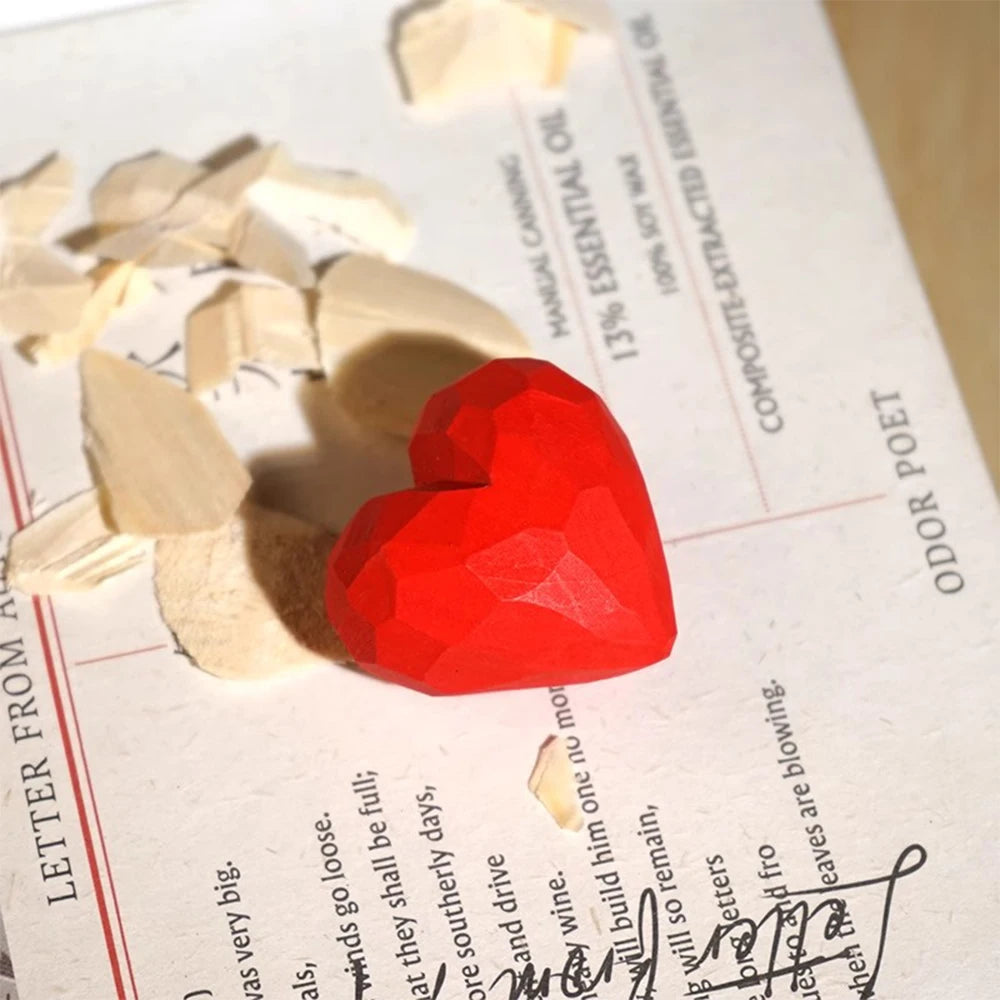 Red heart-shaped object on a piece of paper with text