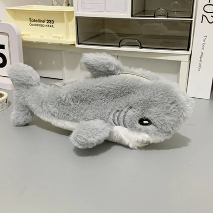 Plush shark toy on a gray surface with a blurred background