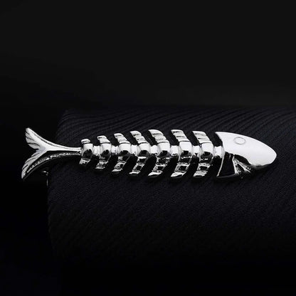 Metallic fish skeleton ornament on a dark textured surface
