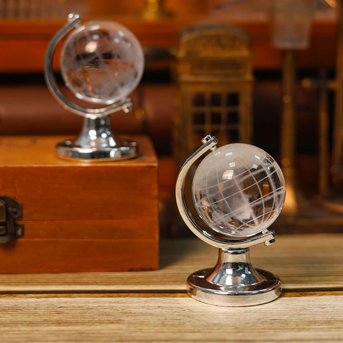 Two crystal globes on a wooden surface with a blurred background