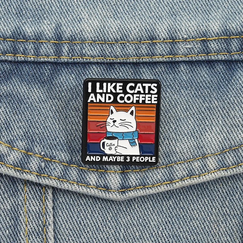 Enamel pin with cat and coffee design on denim fabric