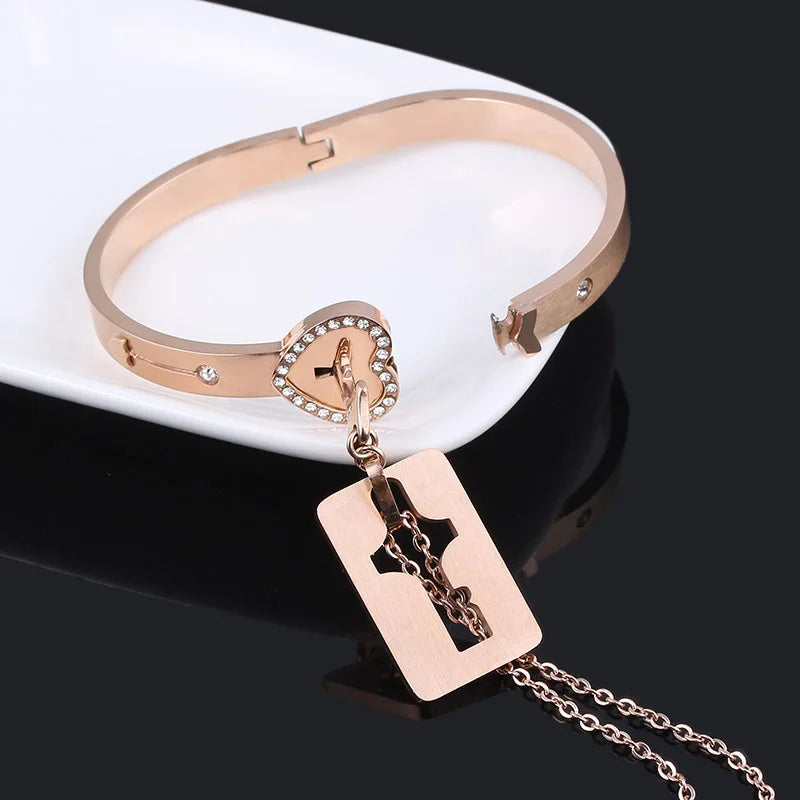 Rose gold bracelet with heart-shaped clasp and cross pendant on a black background