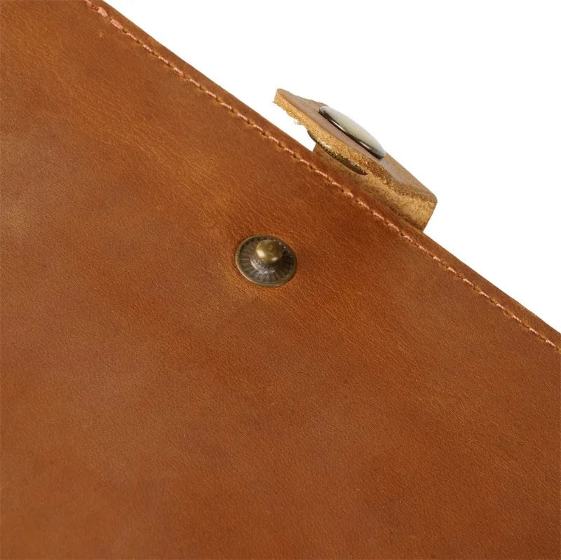 Close-up of a brown leather product with a metallic clasp on a white background
