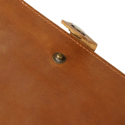 Close-up of a brown leather product with a metallic clasp on a white background