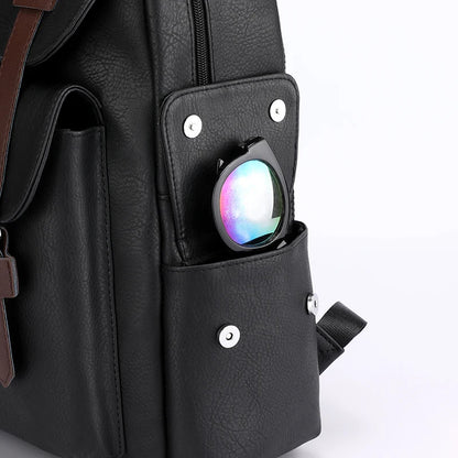 Black backpack with a colorful object in a pocket on a white background