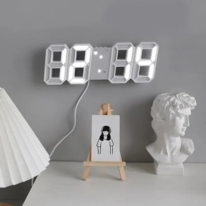 Digital clock on a gray wall with a white lamp and sculpture in the foreground