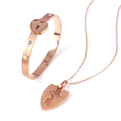 Gold bracelet and necklace with heart-shaped lock design on a white background