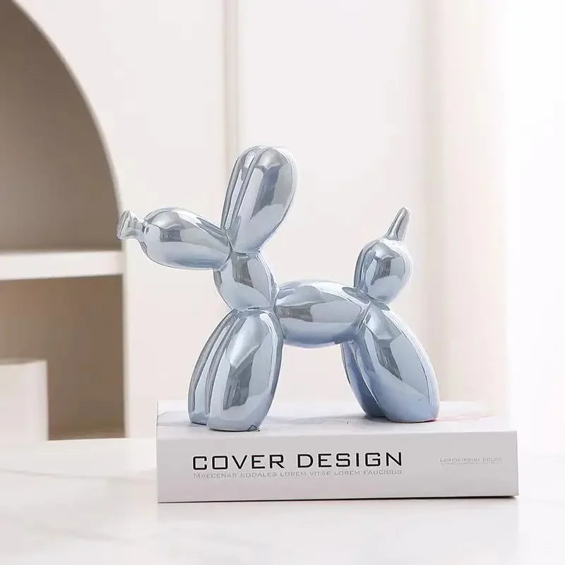 Metallic balloon dog sculpture on a book with 'Cover Design' branding.