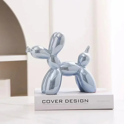 Metallic balloon dog sculpture on a book with 'Cover Design' branding.