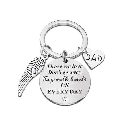 Keychain with angel wing, heart, and 'DAD' tag on a white background