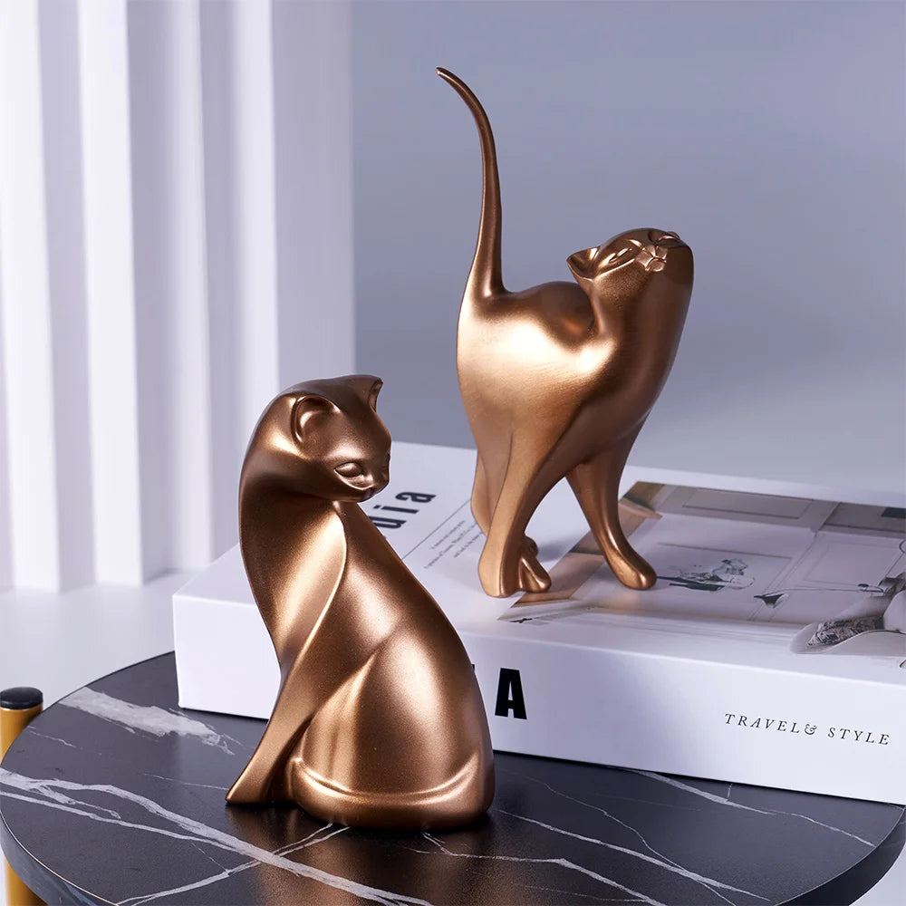 Bronze cat figurines on a magazine with a light gray background
