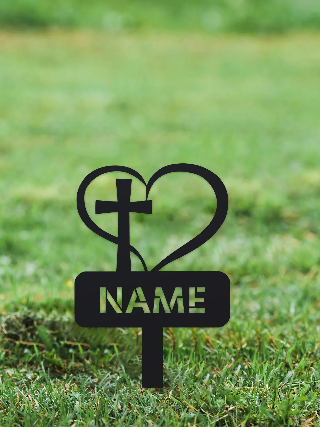 Garden stake with cross and heart design on grass