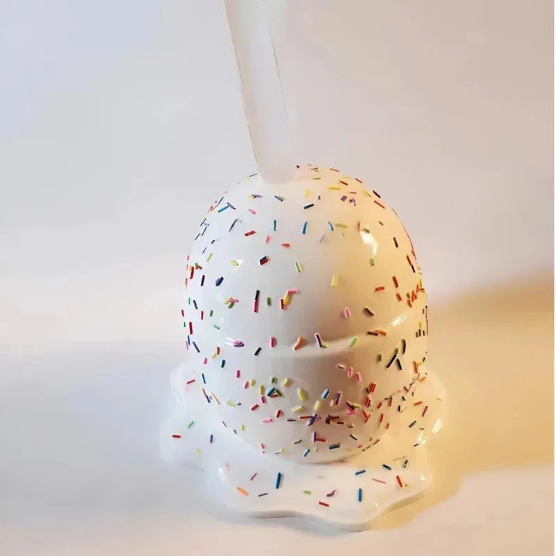 Decorative number 3 shaped like a donut with sprinkles on a light background