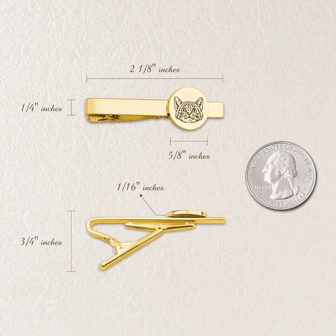 Gold tie clip with engraved design, shown with measurements and a quarter for scale on a light background.