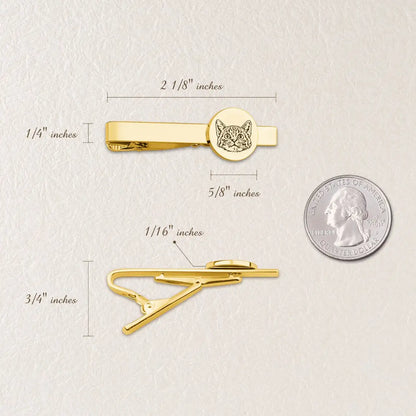 Gold tie clip with engraved design, shown with measurements and a quarter for scale on a light background.