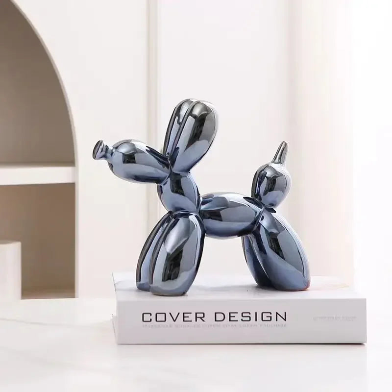 Glossy blue balloon dog sculpture on a white surface with 'Cover Design' book