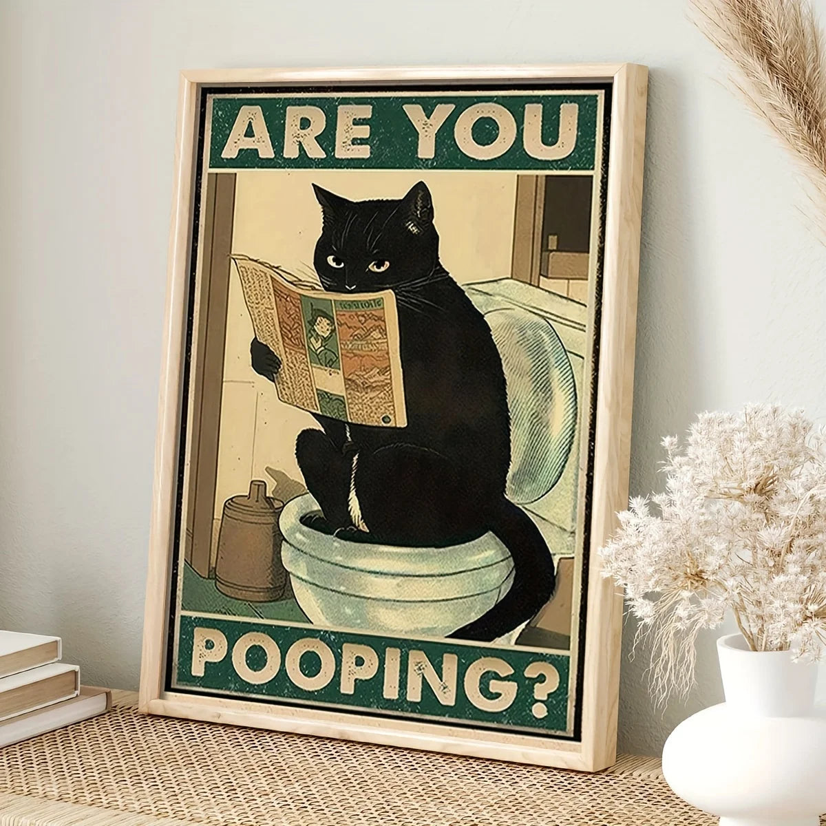Framed poster with a black cat reading a newspaper on a toilet, text 'Are you pooping?' on a light background.