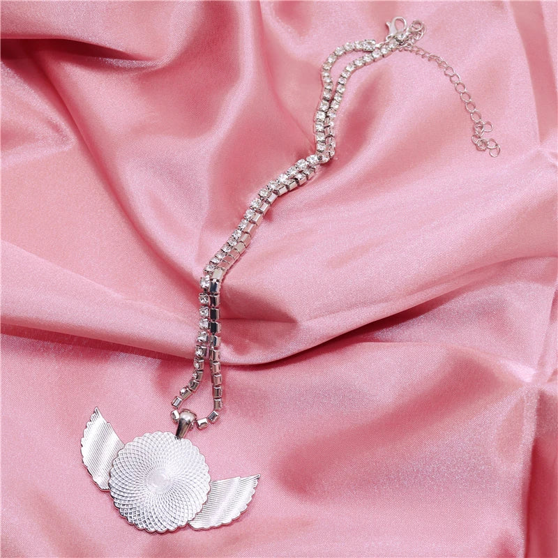 Silver necklace with a leaf pendant on pink fabric