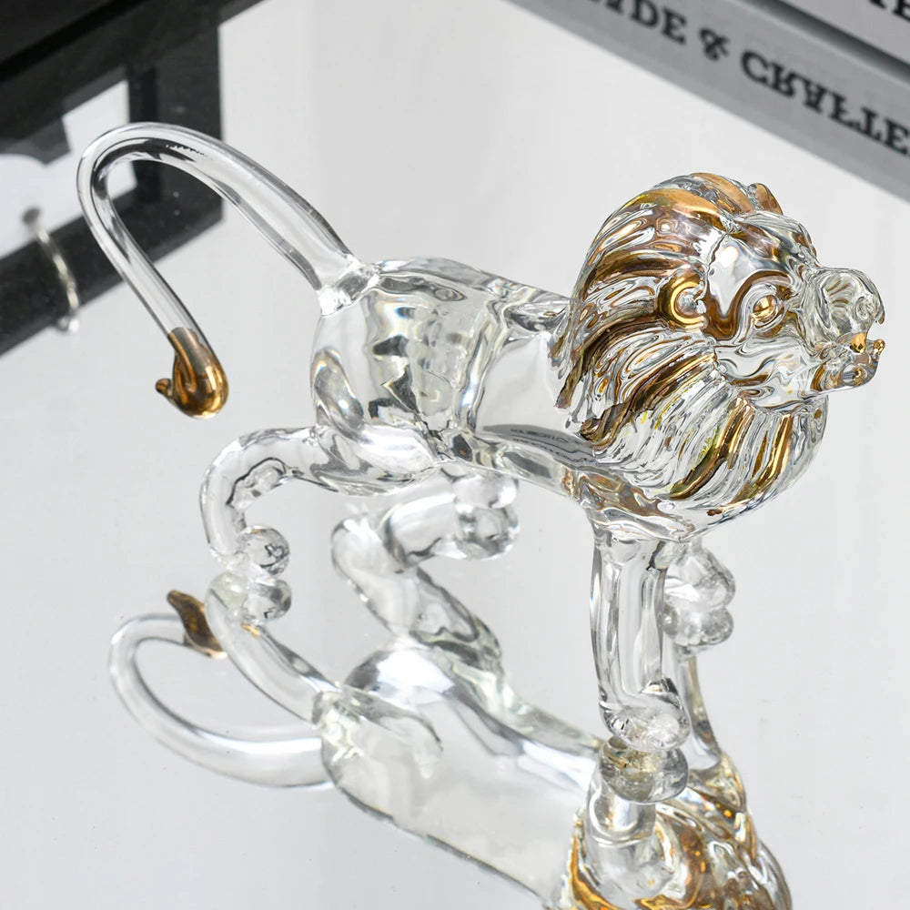 Clear glass lion figurine with gold accents on a white background