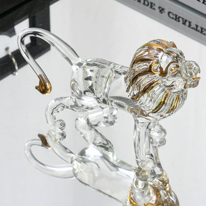 Clear glass lion figurine with gold accents on a white background