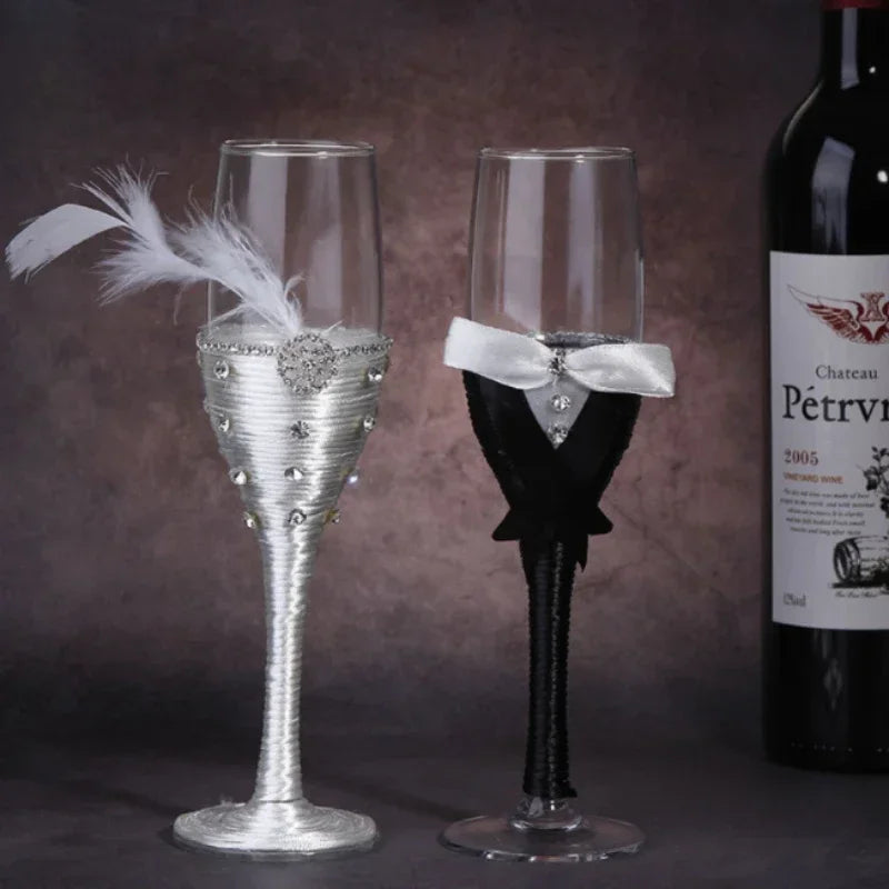 Two decorative wine glasses, one silver and one black with a bow, next to a bottle of Chateau Petrus.