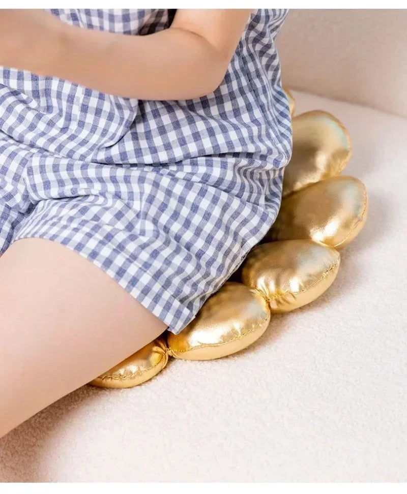 Person wearing blue checkered shorts with gold eggs on a light background