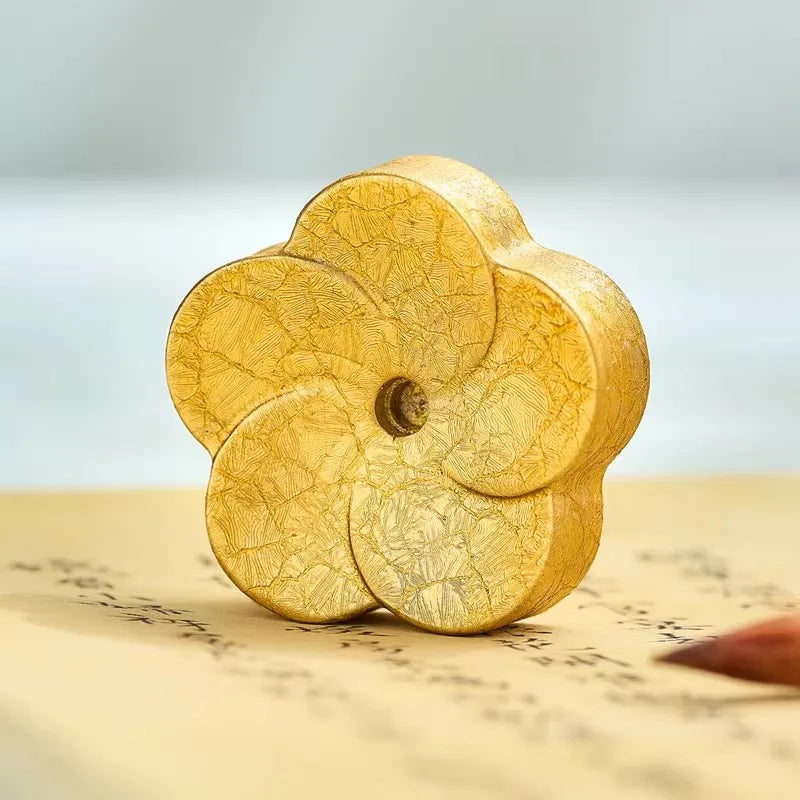 Gold decorative item on a textured surface with a blurred background