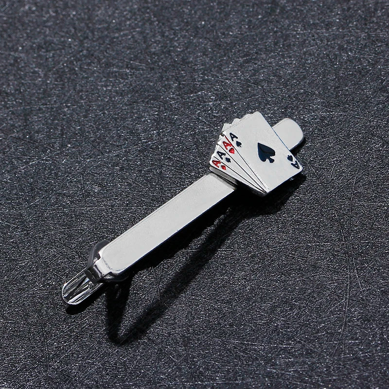 Metallic tie clip with playing card design on a dark textured background