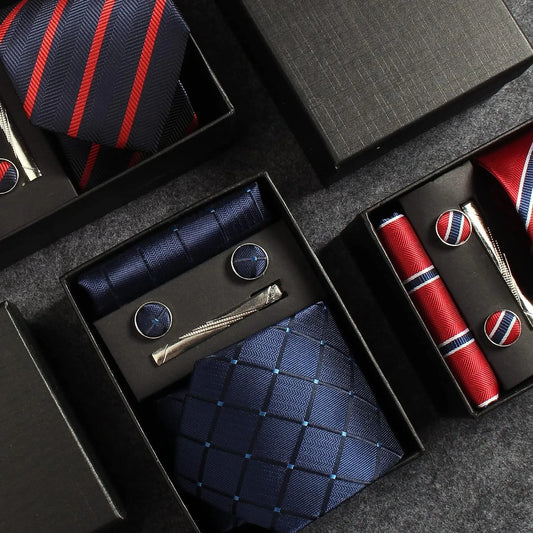 Collection of neckties, cufflinks, and accessories in black boxes on a dark surface