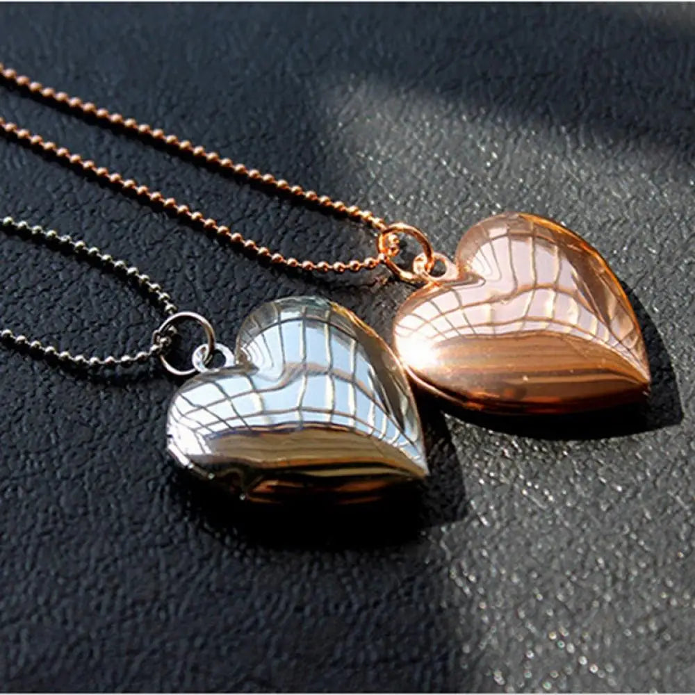 Two heart-shaped pendants on chains against a dark background