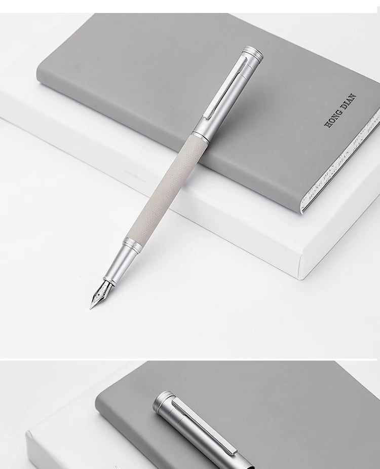 Silver pen on a gray notebook with a white background