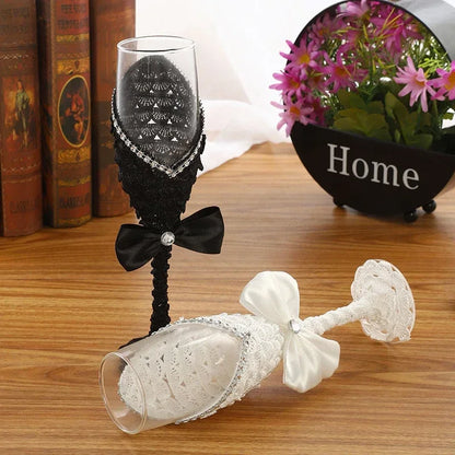 Decorative wine glasses with black and white lace designs on a wooden surface.