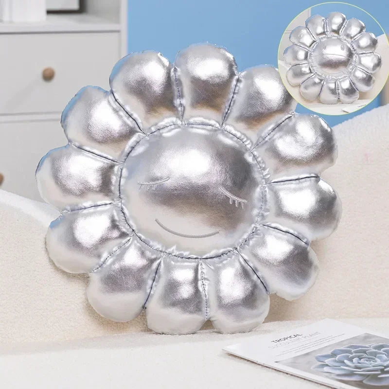 Silver flower-shaped pillow on a couch with a close-up inset of the flower design.